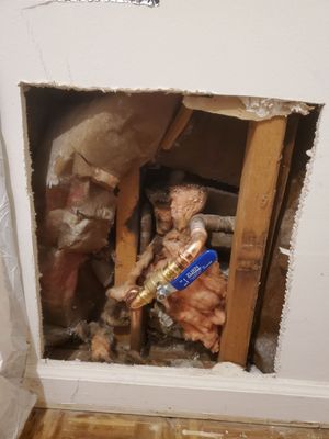 Done Right Drywall — open wall section showing water-leak source with exposed shutoff valve, insulation cut back for inspection